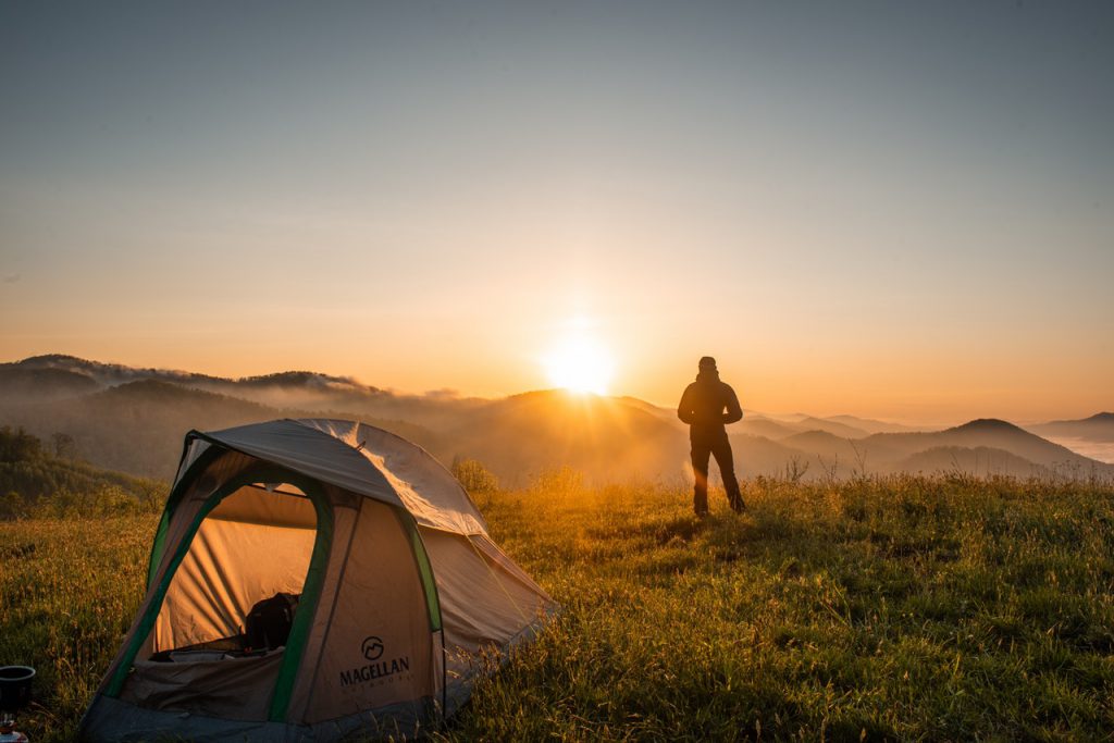 silhouette of person standing near camping tent 2398220
